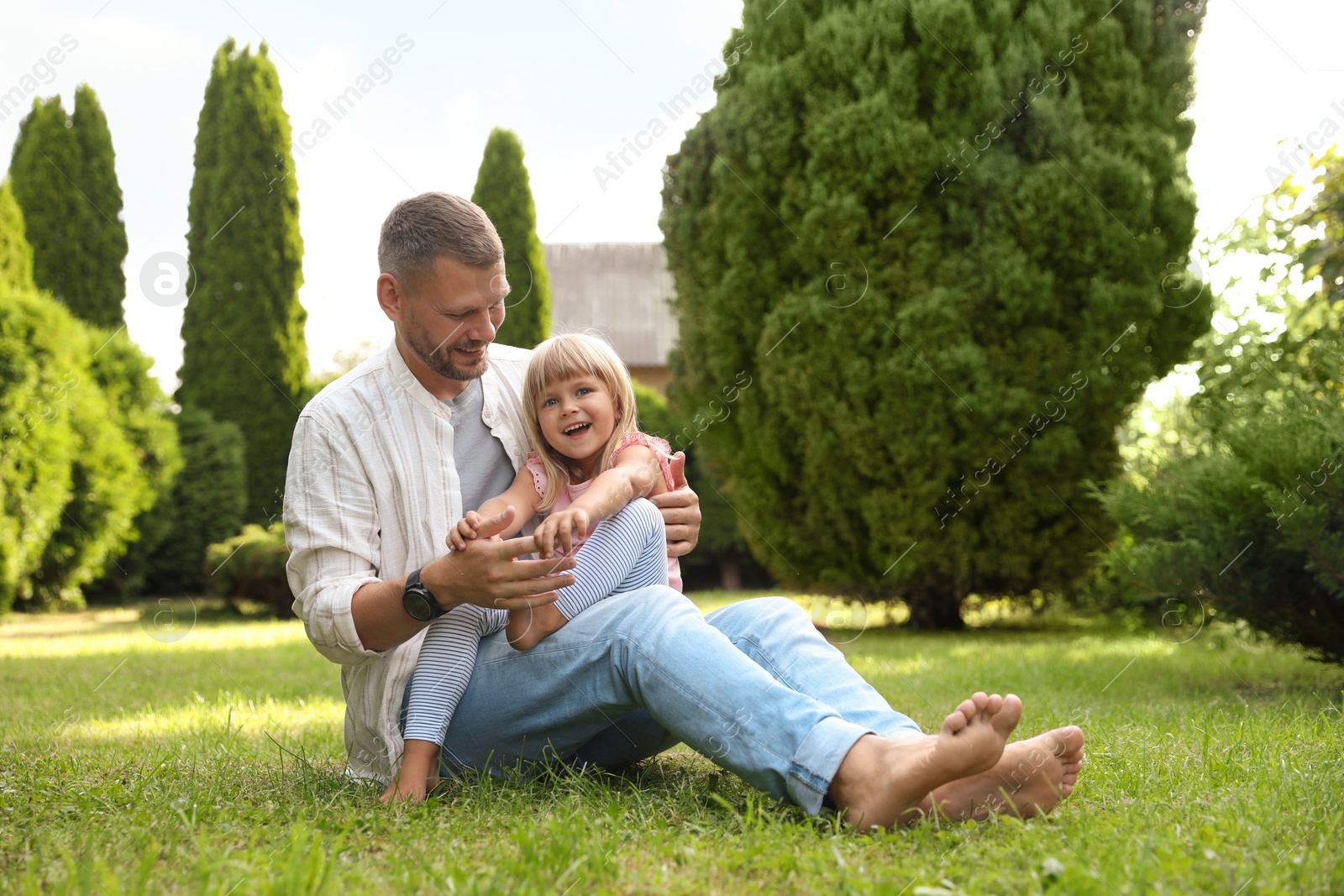 Photo of Father and his daughter spending time together on green lawn in park