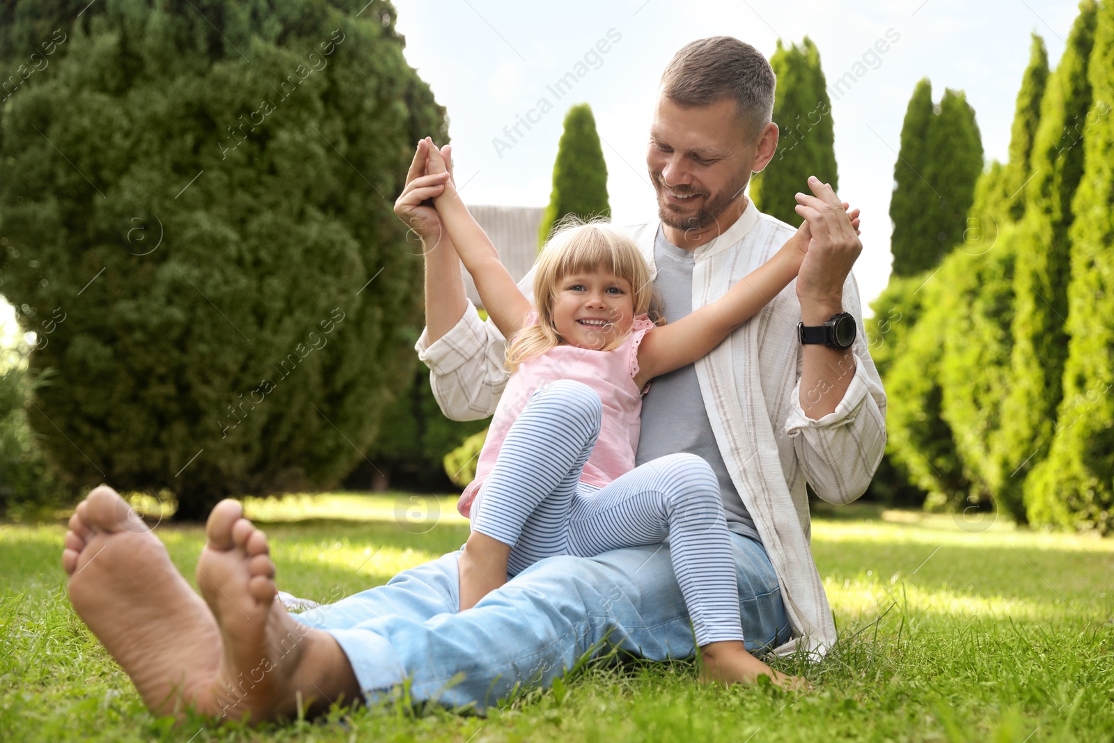 Photo of Father and his daughter spending time together on green lawn in park