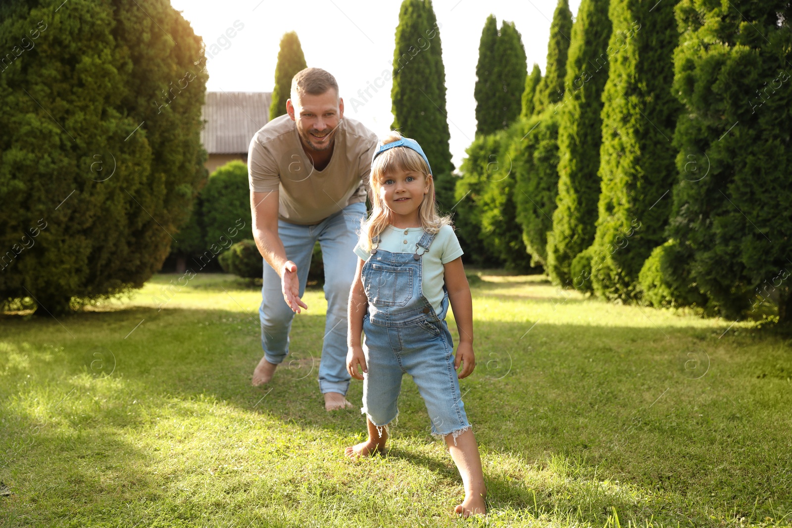 Photo of Father and his daughter spending time together on green lawn in park