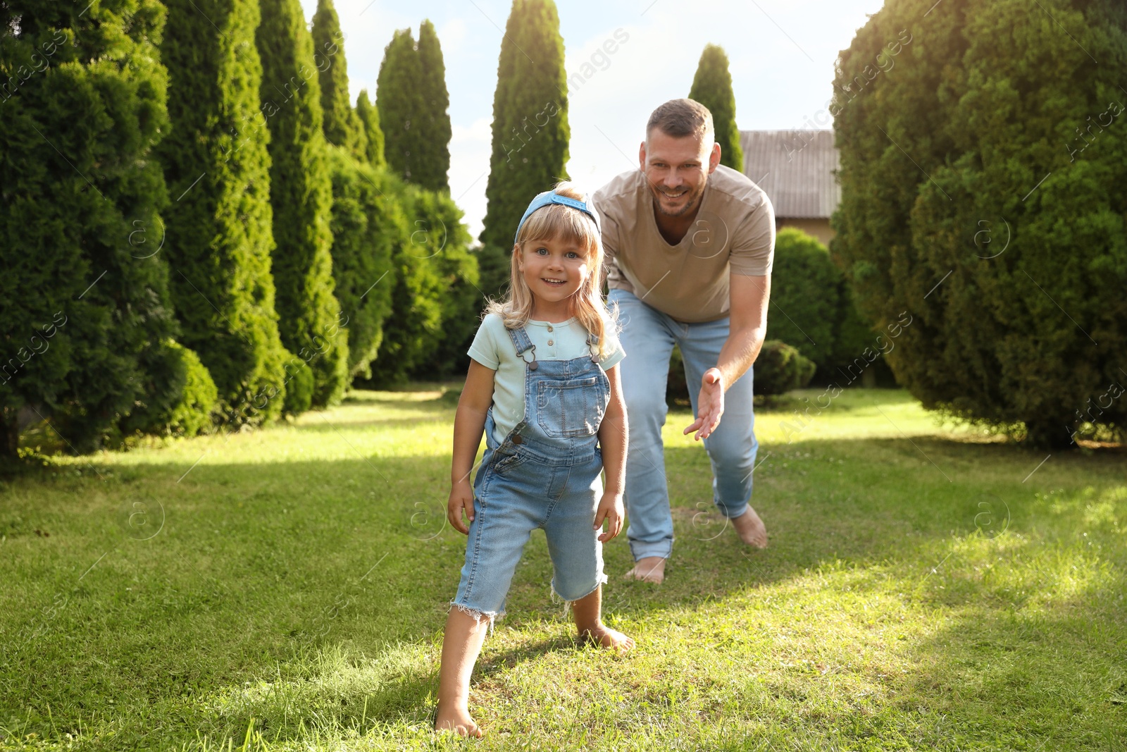 Photo of Father and his daughter spending time together on green lawn in park