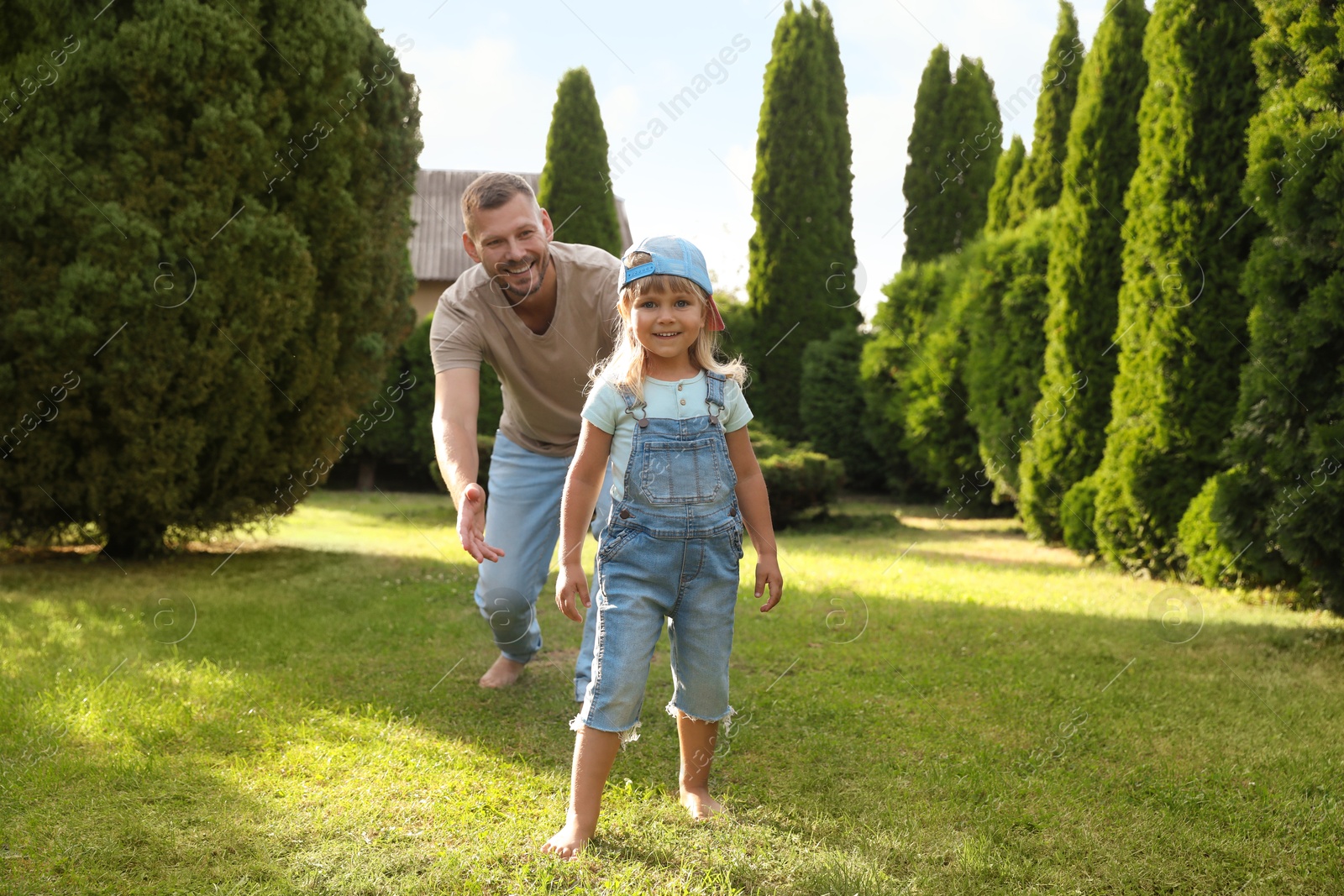 Photo of Father and his daughter spending time together on green lawn in park