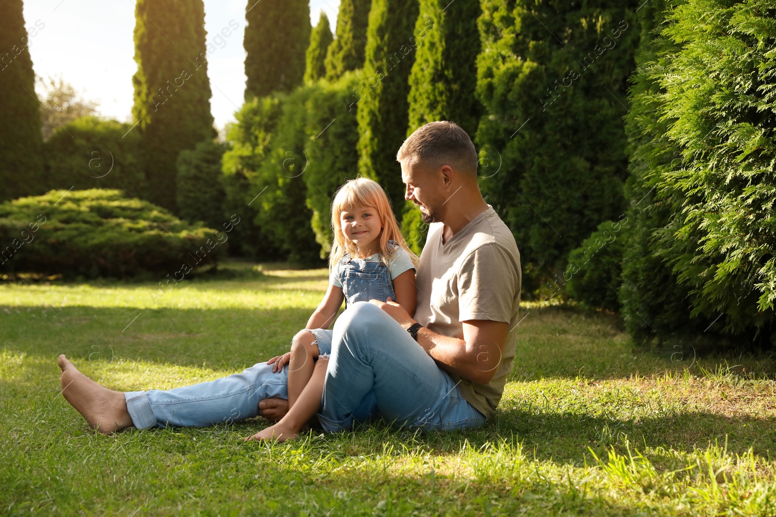 Photo of Father and his daughter spending time together on green lawn in park