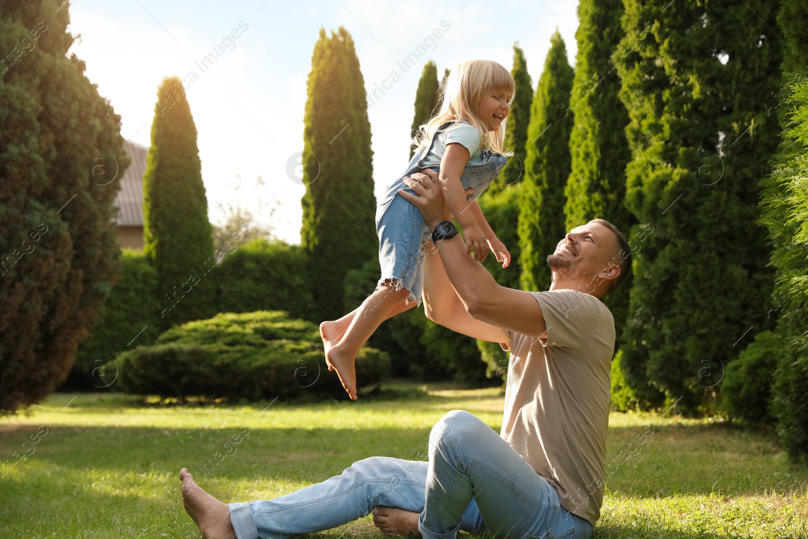 Photo of Father and his daughter spending time together on green lawn in park