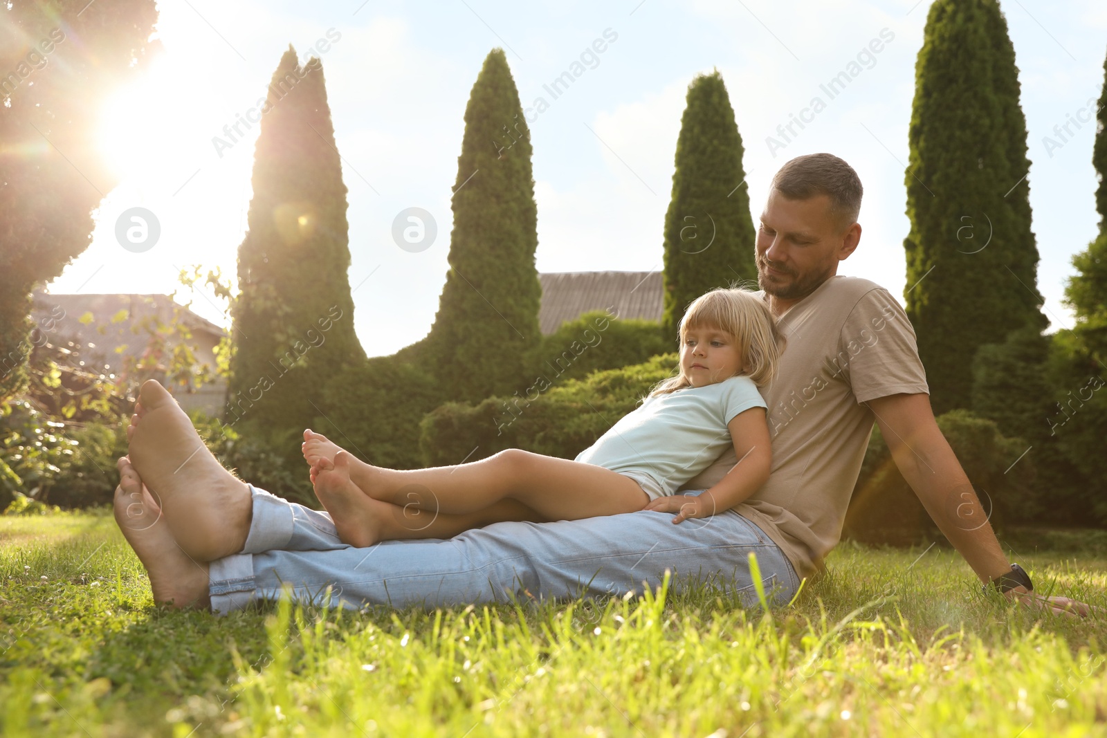 Photo of Father and his daughter spending time together on green lawn in park