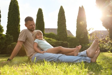 Father and his daughter spending time together on green lawn in park