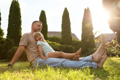 Photo of Father and his daughter spending time together on green lawn in park