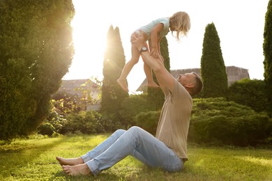 Photo of Father and his daughter spending time together on green lawn in park