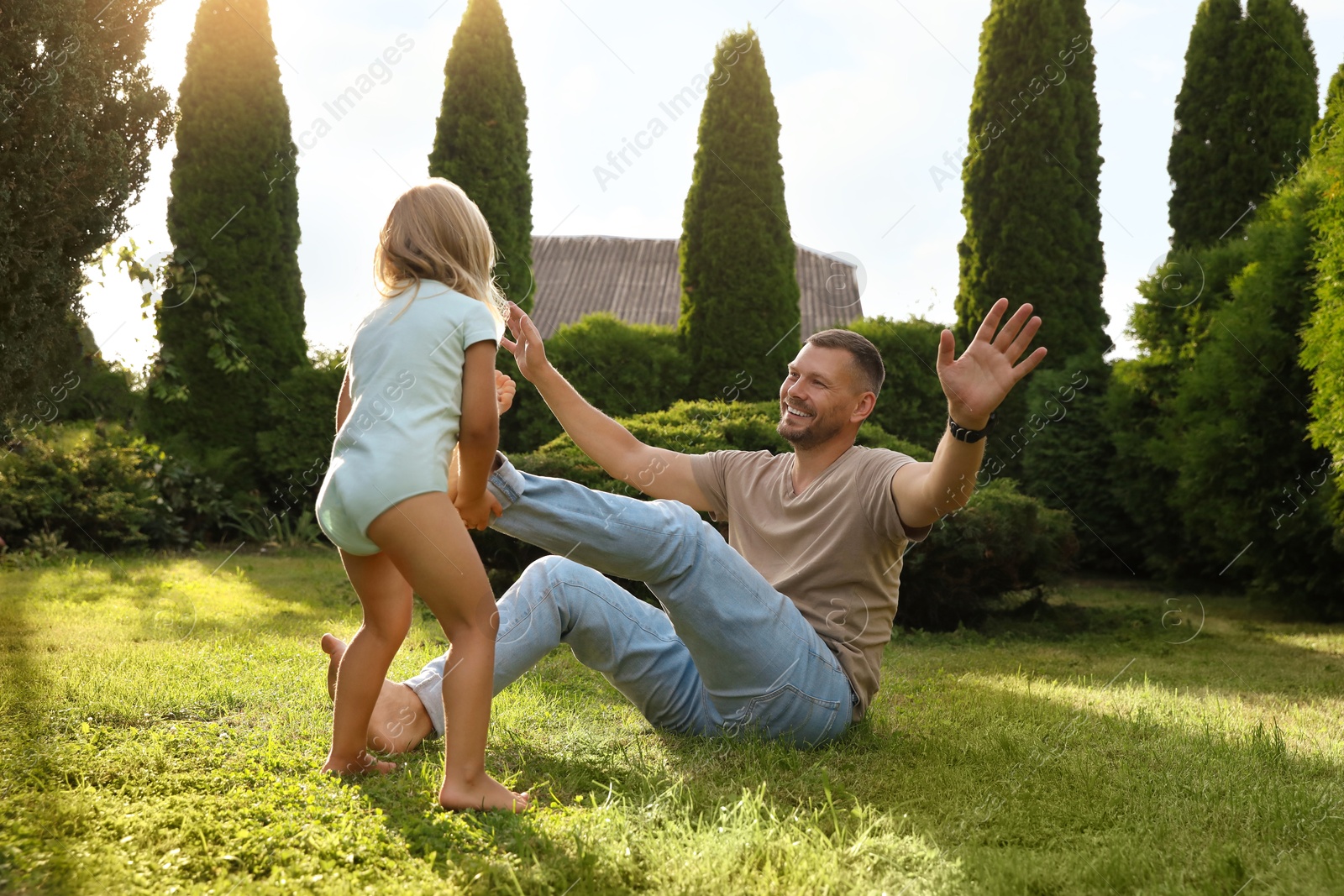 Photo of Father and his daughter spending time together on green lawn in park