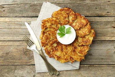 Photo of Delicious potato pancakes served on wooden table, flat lay