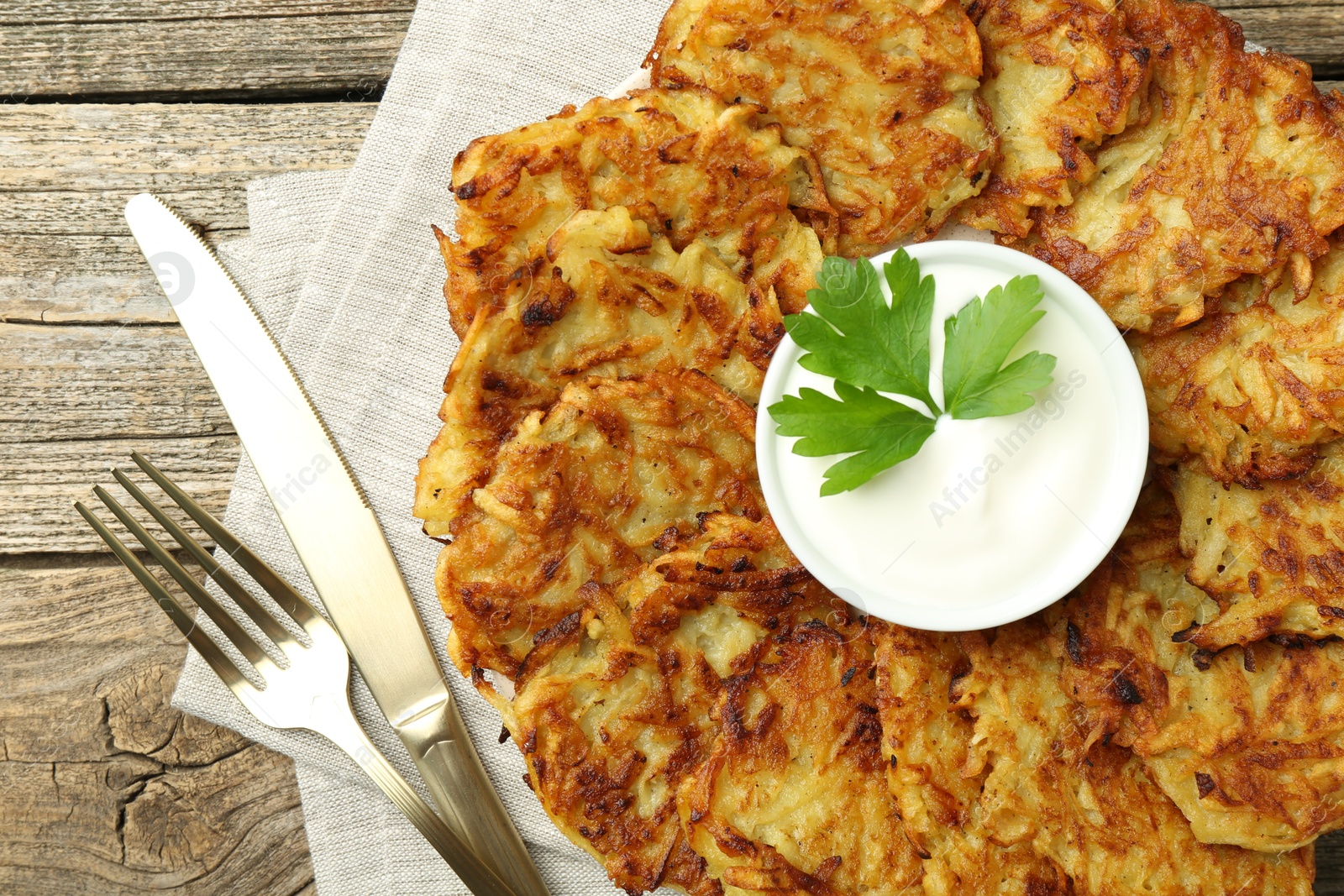 Photo of Delicious potato pancakes served on wooden table, flat lay