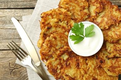 Photo of Delicious potato pancakes served on wooden table, flat lay