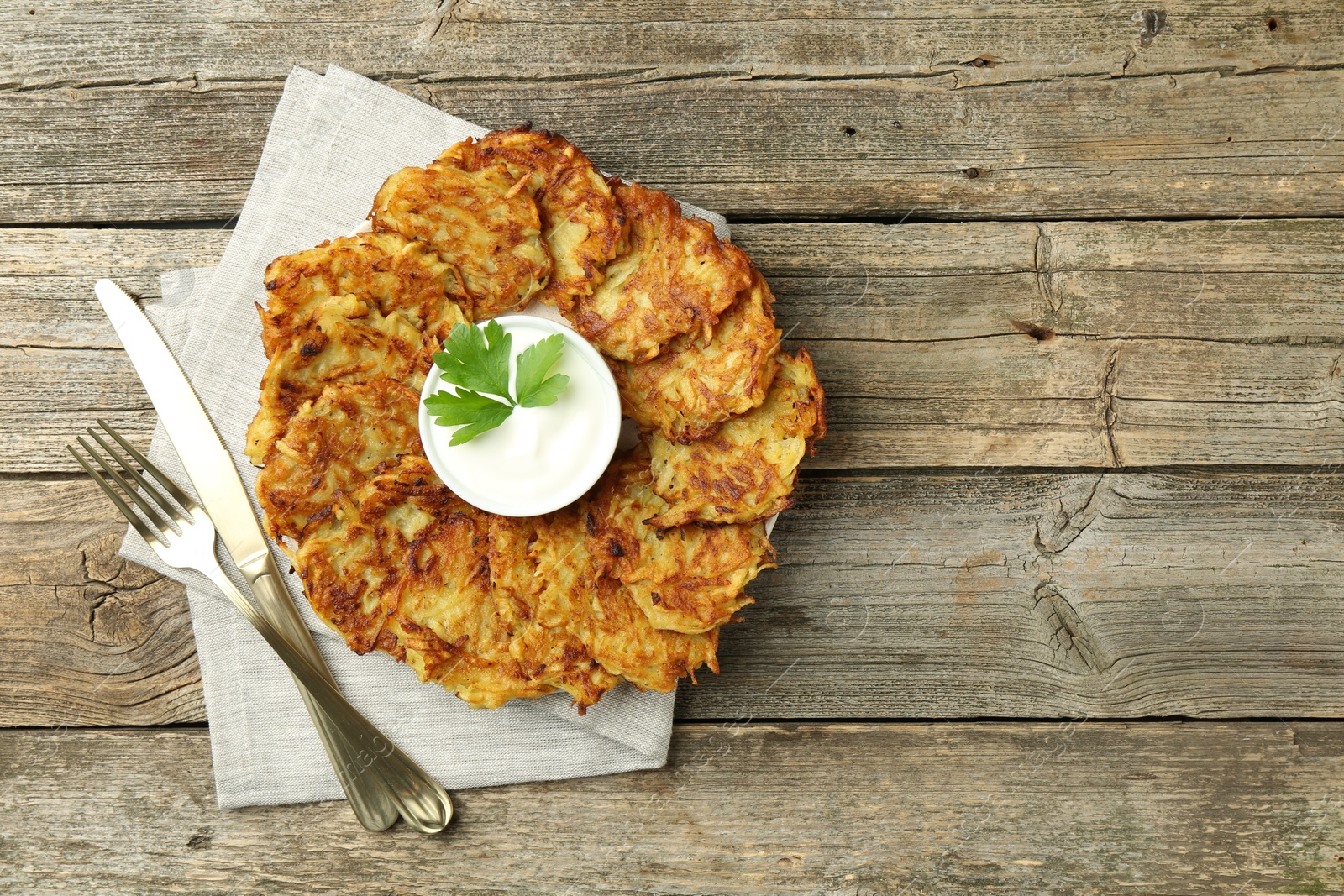 Photo of Delicious potato pancakes served on wooden table, flat lay. Space for text