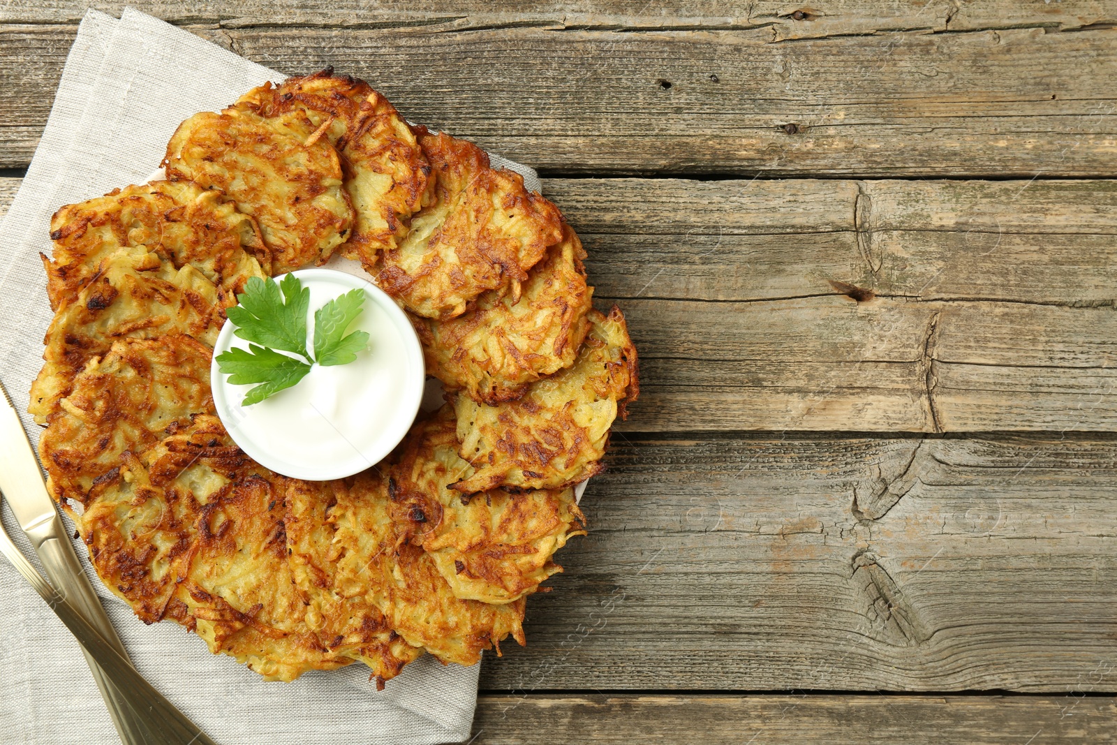 Photo of Delicious potato pancakes served on wooden table, flat lay. Space for text