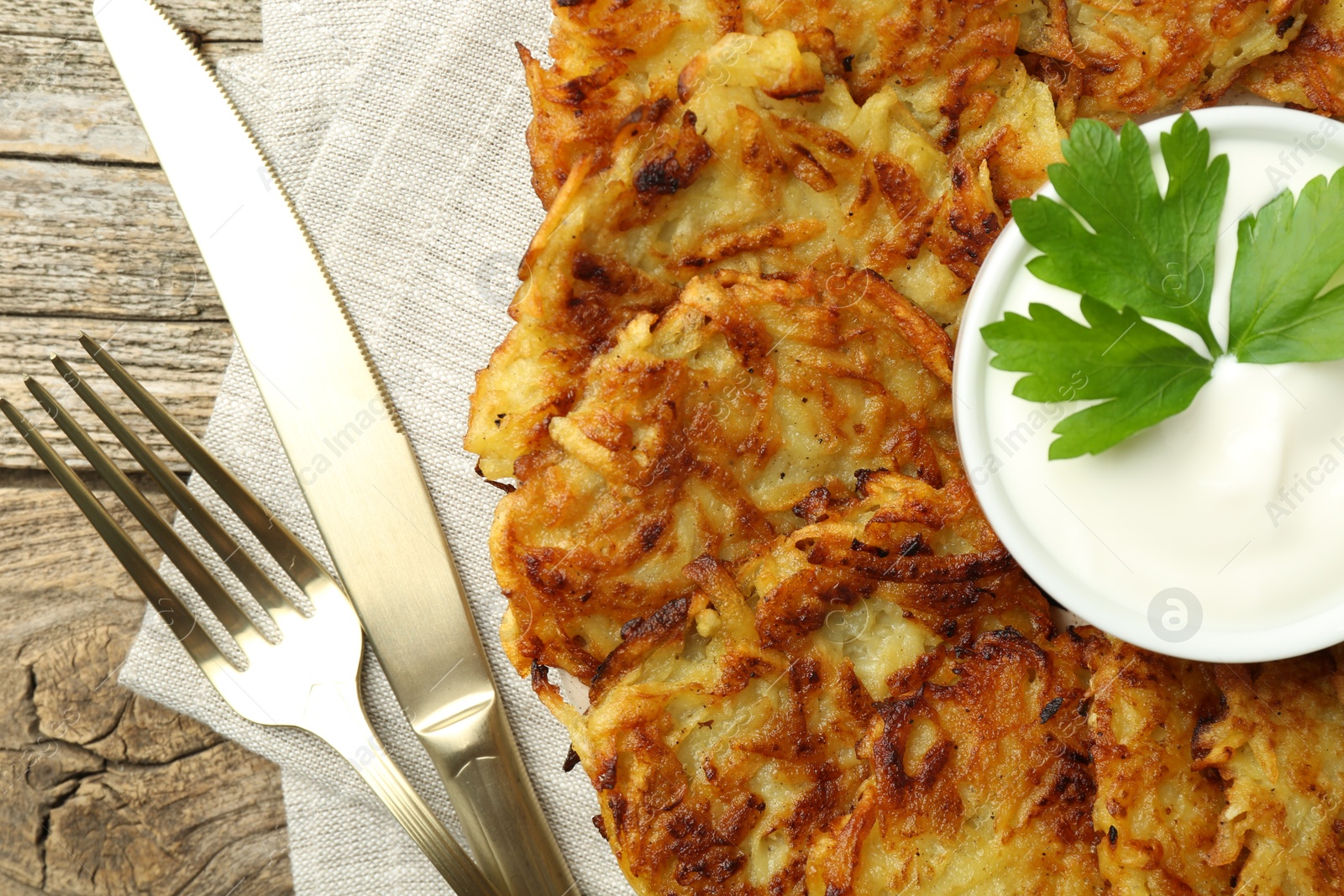 Photo of Delicious potato pancakes served on wooden table, flat lay