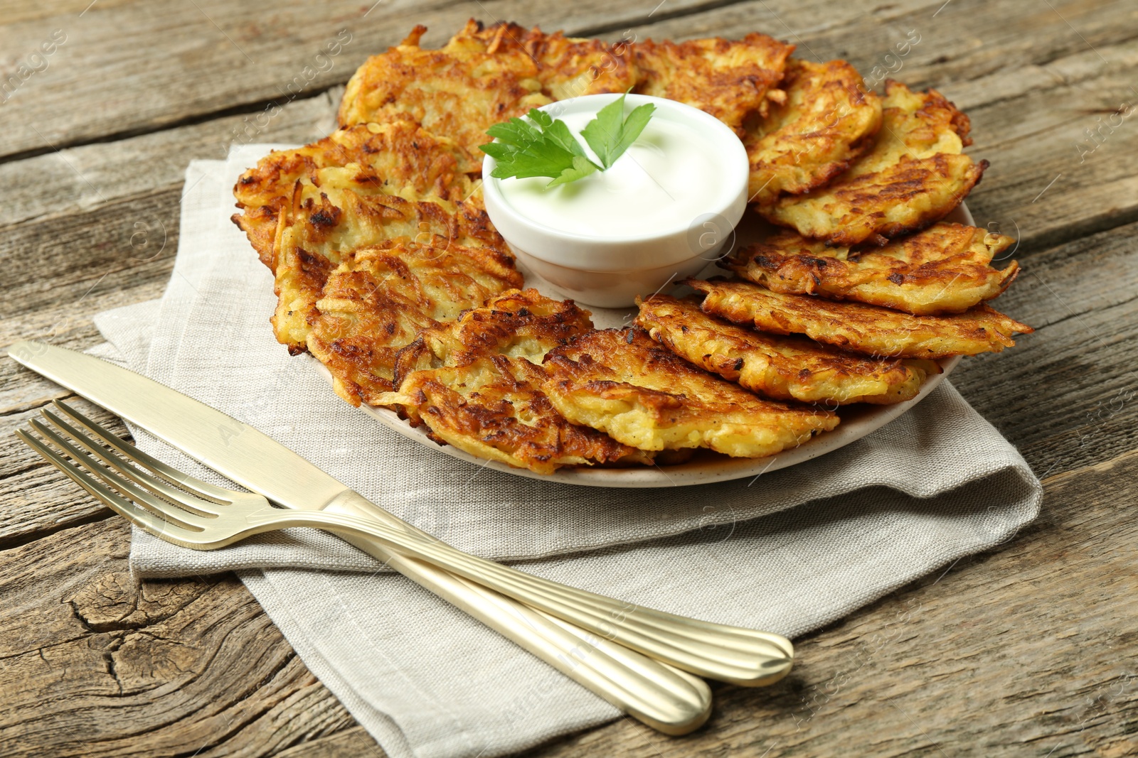 Photo of Delicious potato pancakes served on wooden table, closeup