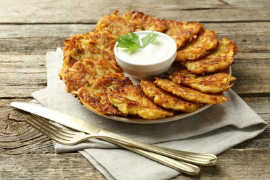 Photo of Delicious potato pancakes served on wooden table, closeup