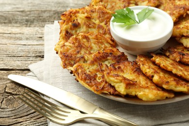 Photo of Delicious potato pancakes served on wooden table, closeup