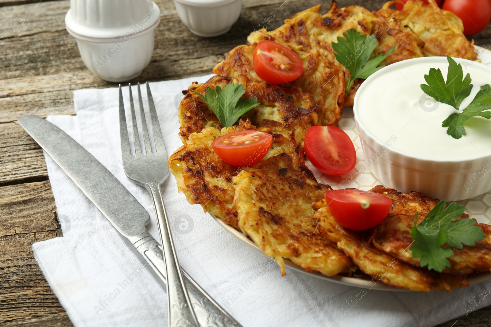 Photo of Delicious potato pancakes served on wooden table, closeup