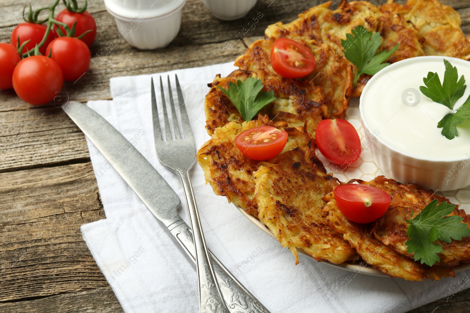 Photo of Delicious potato pancakes served on wooden table, closeup