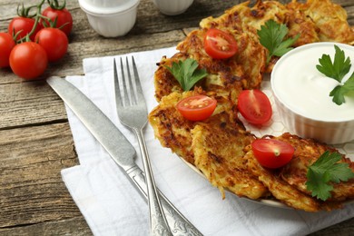 Photo of Delicious potato pancakes served on wooden table, closeup