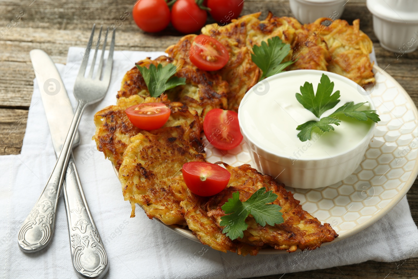 Photo of Delicious potato pancakes served on wooden table, closeup