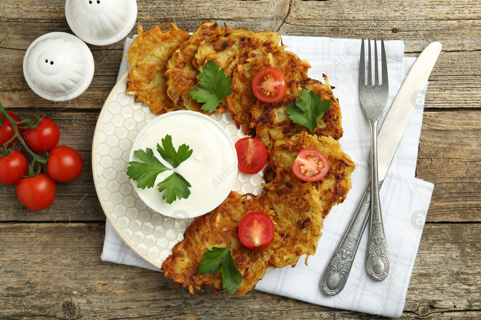 Photo of Delicious potato pancakes served on wooden table, flat lay