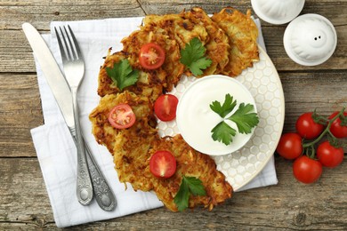 Photo of Delicious potato pancakes served on wooden table, flat lay