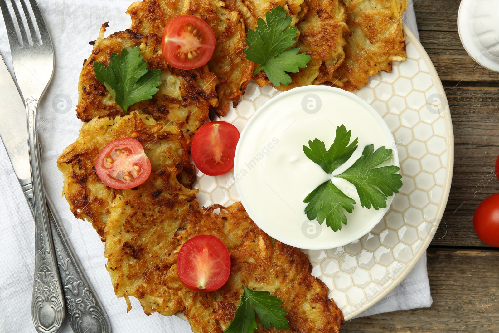 Photo of Delicious potato pancakes served on wooden table, flat lay