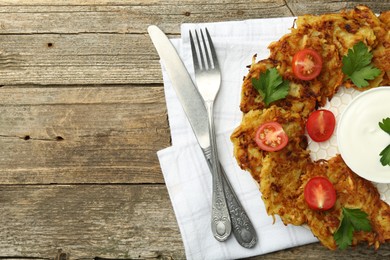 Photo of Delicious potato pancakes served on wooden table, flat lay. Space for text