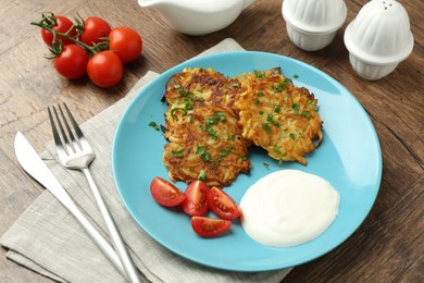 Photo of Delicious potato pancakes served on wooden table, closeup