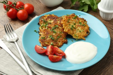 Photo of Delicious potato pancakes served on wooden table, closeup