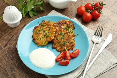 Photo of Delicious potato pancakes served on wooden table, closeup