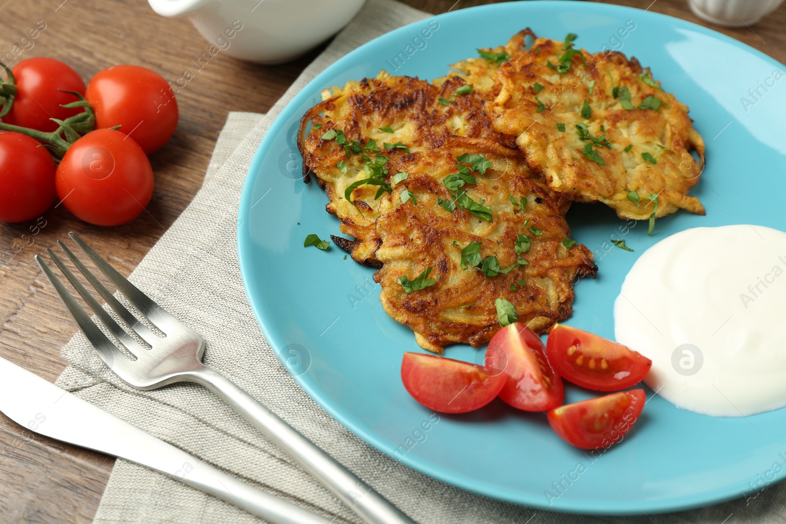 Photo of Delicious potato pancakes served on wooden table, closeup