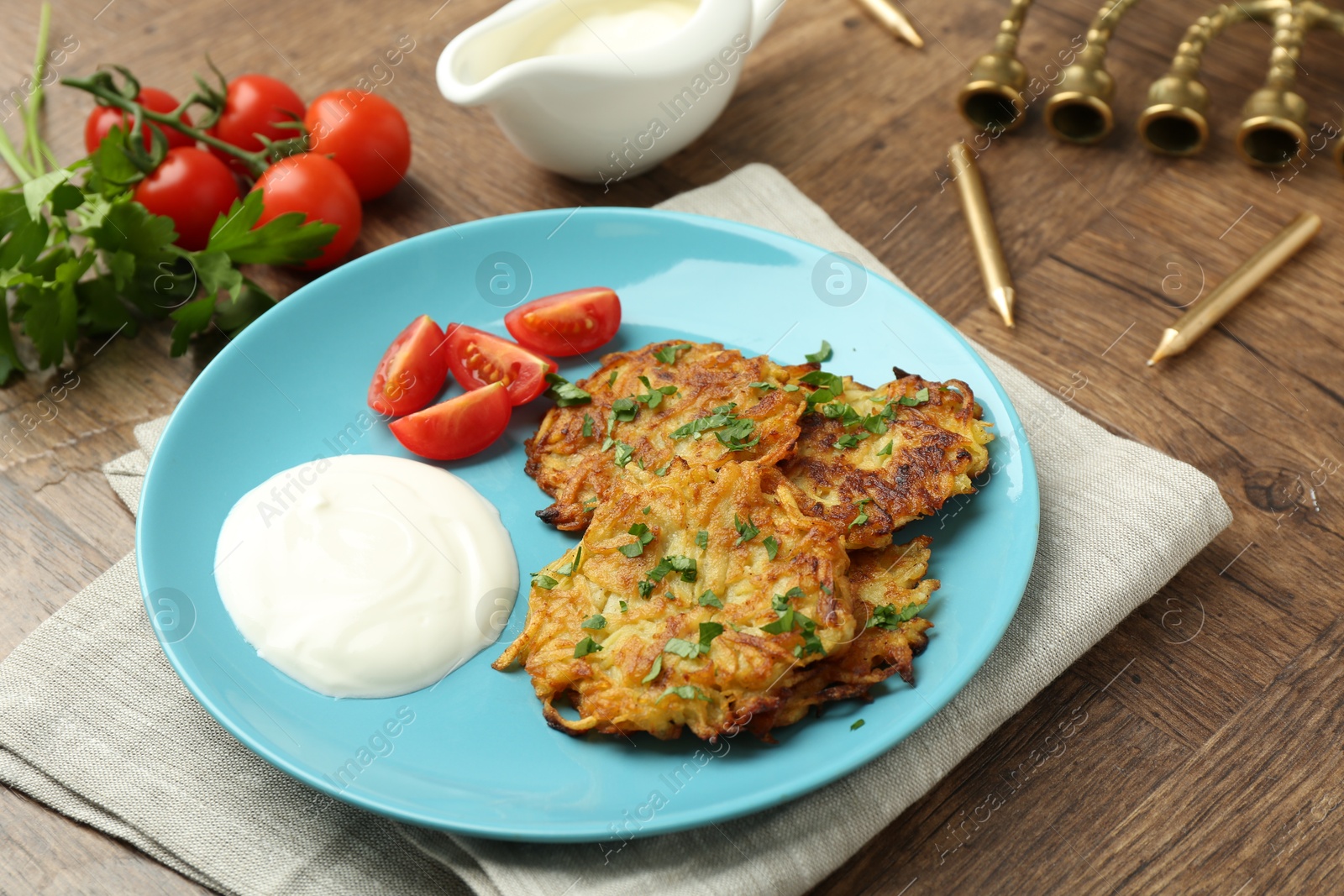 Photo of Delicious potato pancakes, menorah and candles on wooden table, closeup. Hanukkah festive food