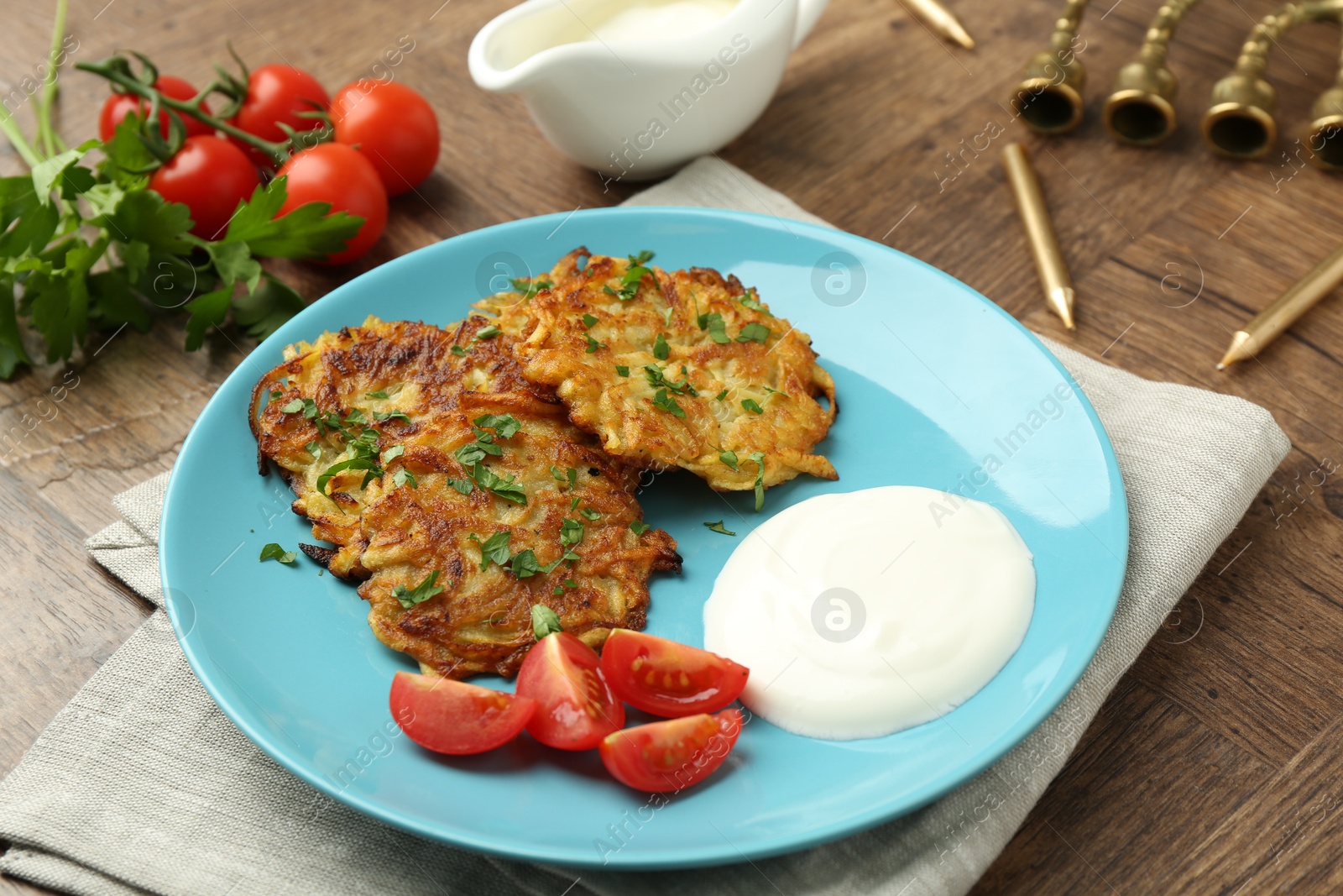 Photo of Delicious potato pancakes, menorah and candles on wooden table, closeup. Hanukkah festive food