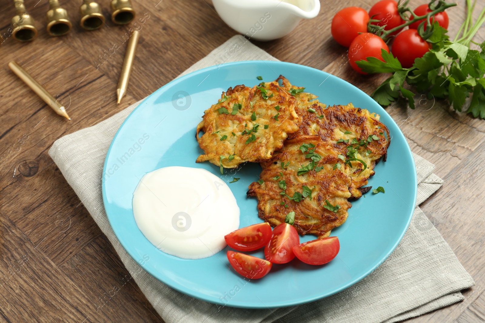 Photo of Delicious potato pancakes, menorah and candles on wooden table, closeup. Hanukkah festive food