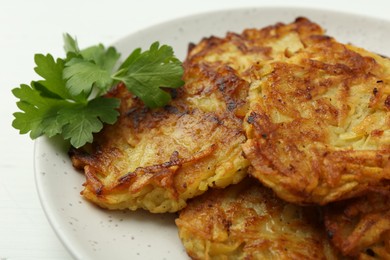 Photo of Delicious potato pancakes and parsley on table, closeup