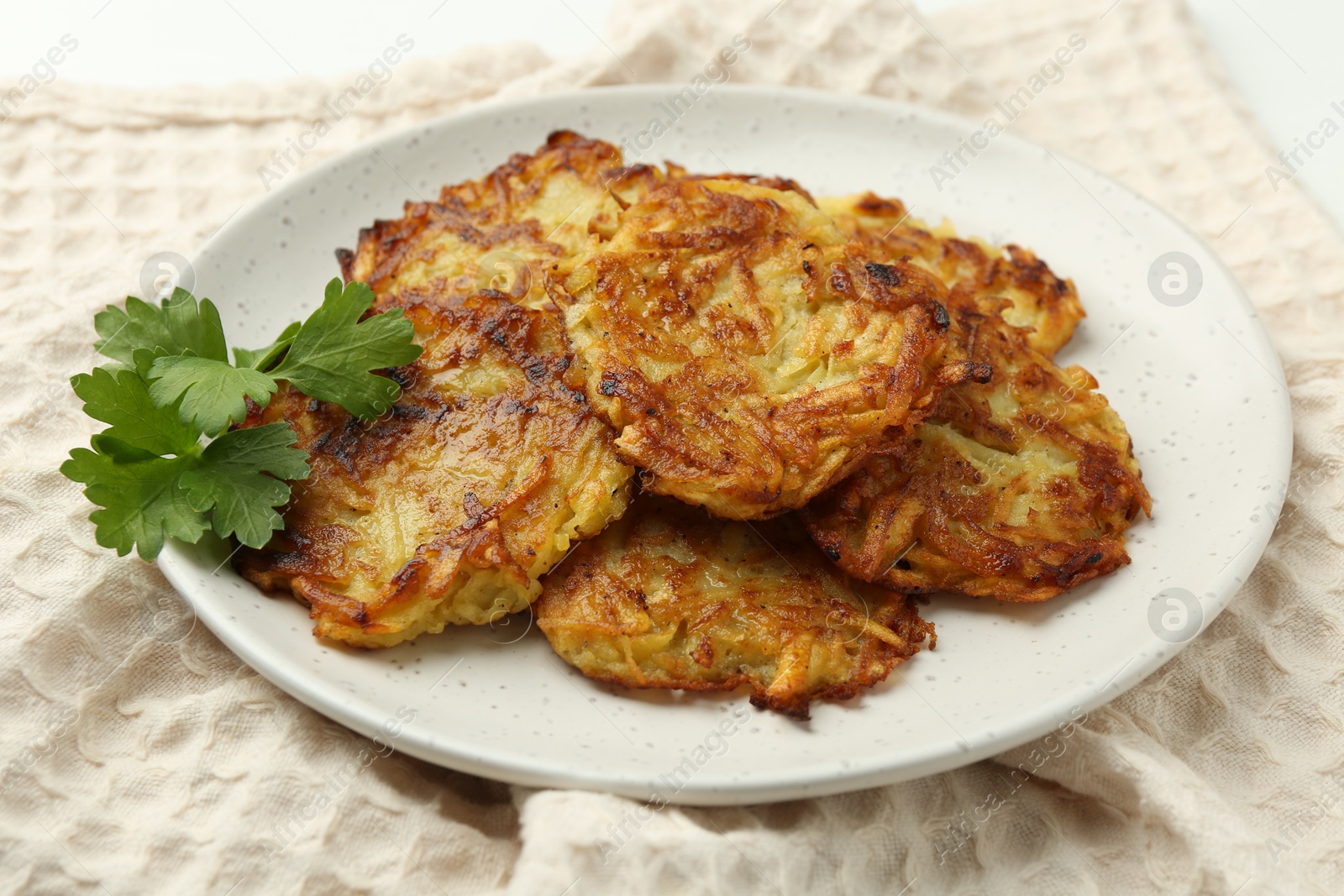 Photo of Delicious potato pancakes and parsley on table, closeup