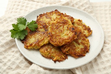 Photo of Delicious potato pancakes and parsley on table, closeup