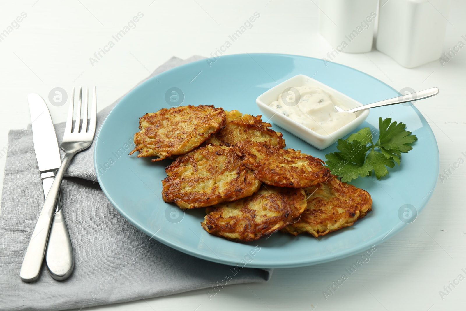 Photo of Delicious potato pancakes served on white wooden table, closeup