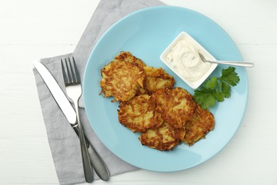 Photo of Delicious potato pancakes served on white wooden table, flat lay