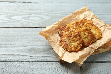 Photo of Delicious potato pancakes on grey wooden table, space for text