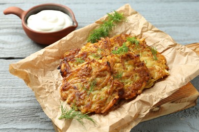 Photo of Delicious potato pancakes served on grey wooden table, closeup