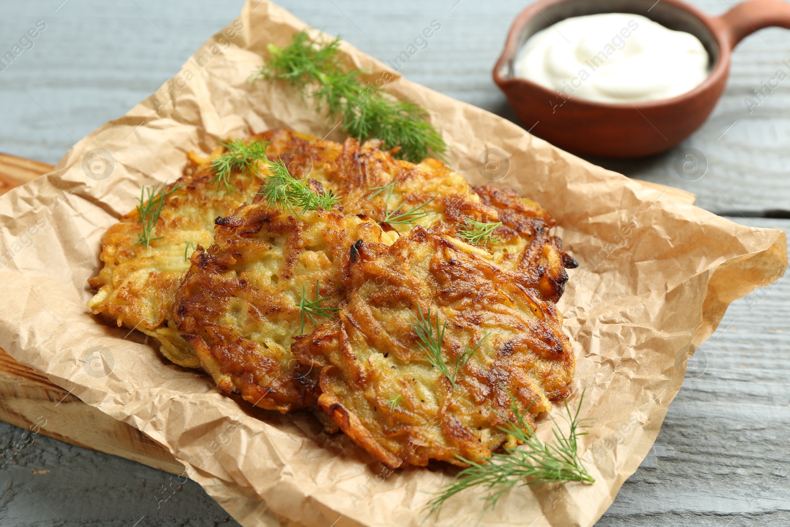 Photo of Delicious potato pancakes served on grey wooden table, closeup