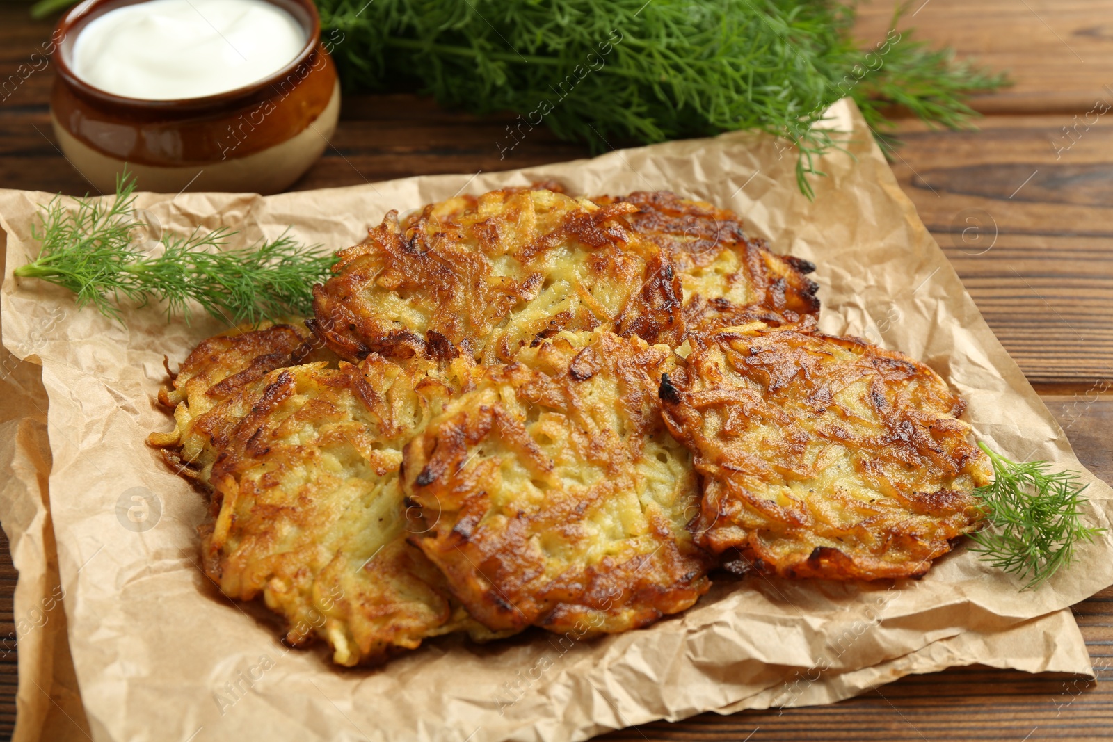 Photo of Delicious potato pancakes served on wooden table, closeup