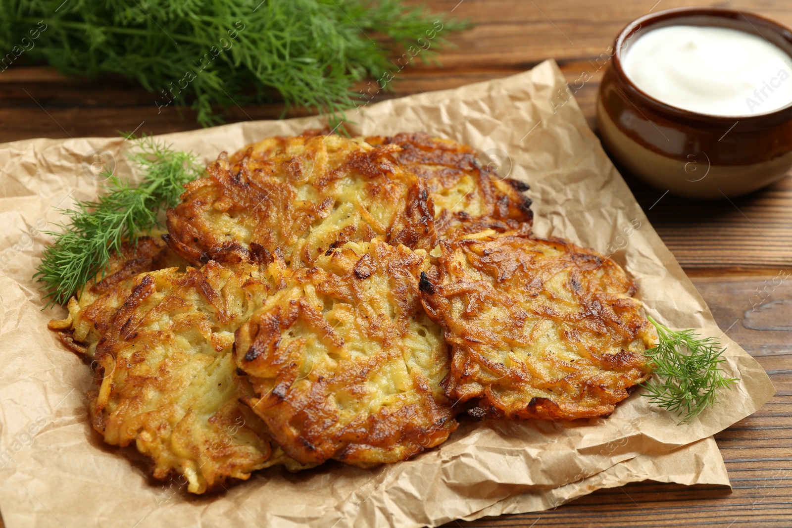 Photo of Delicious potato pancakes served on wooden table, closeup