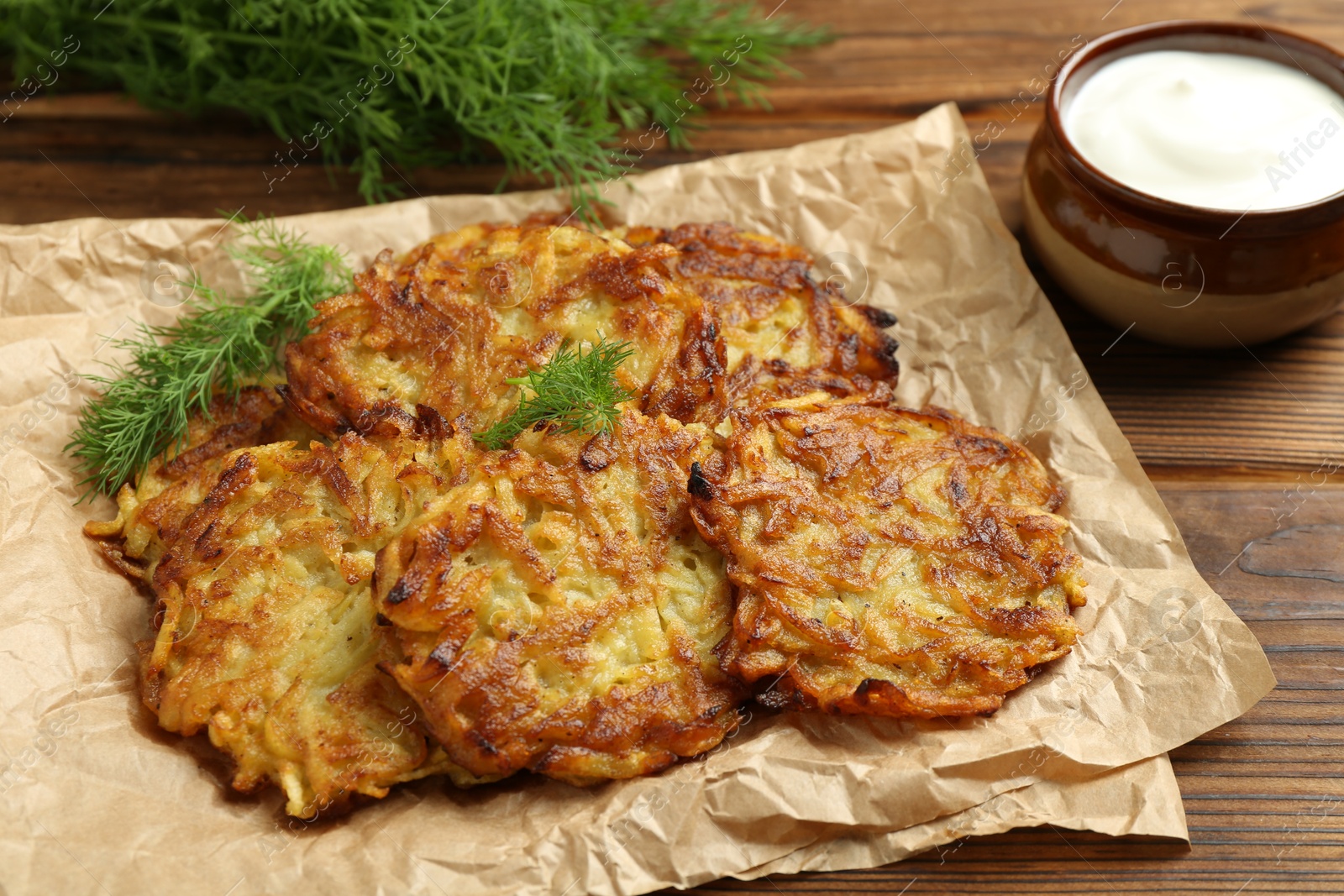 Photo of Delicious potato pancakes served on wooden table, closeup