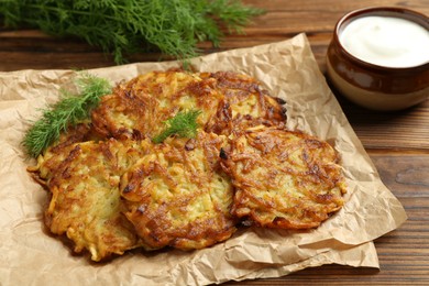 Photo of Delicious potato pancakes served on wooden table, closeup