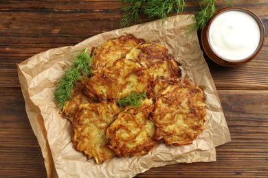 Photo of Delicious potato pancakes served on wooden table, flat lay