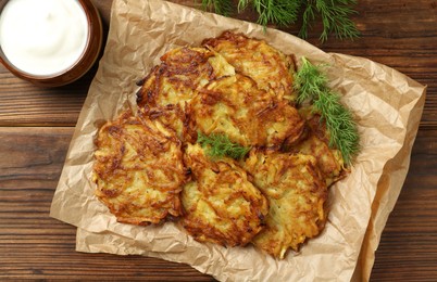 Photo of Delicious potato pancakes served on wooden table, flat lay